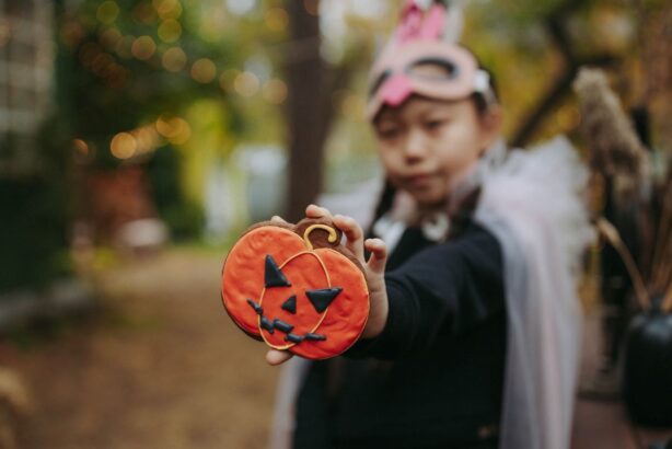 girl holding halloween cookie
